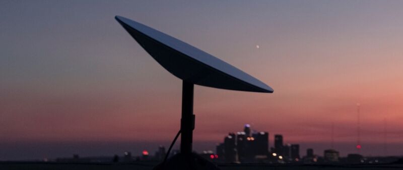 La estación de usuario SpaceX Starlink, también conocida como antena parabólica, se ve frente al horizonte de la ciudad.