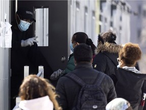 Un guardia de seguridad da instrucciones a las personas que esperan en la fila para tomar una prueba de COVID-19 en el Hospital General Judío de Montreal el 23 de marzo de 2021.